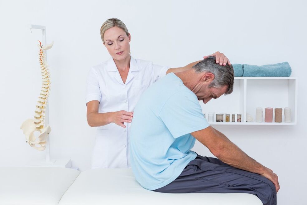 gydytojas apžiūri nugarą su osteochondroze